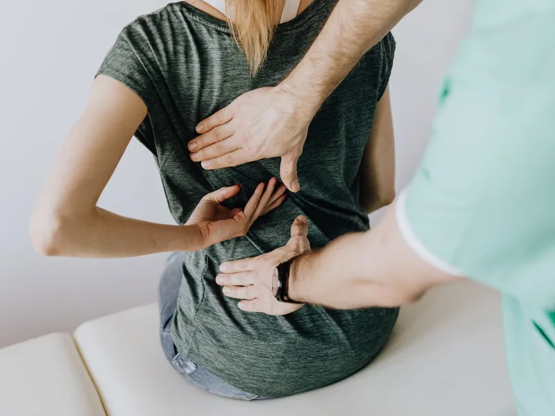 Chiropractor examining a patient's lower back