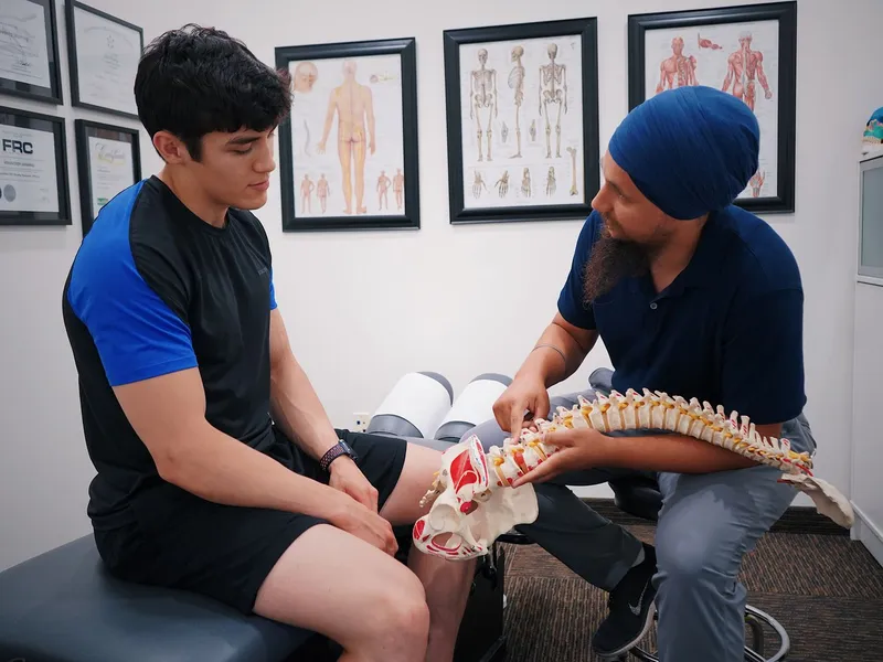 Chiropractor explaining the spine to a patient with a spine model