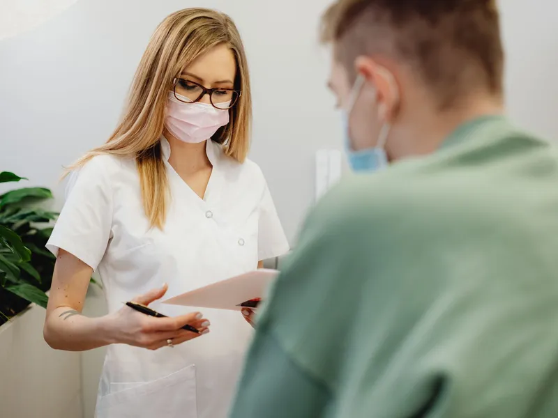 Receptionist helping a patient at a clinic front desk