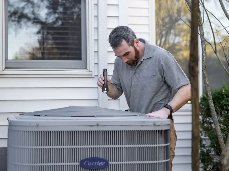 Technician inspecting an outdoor air conditioning unit