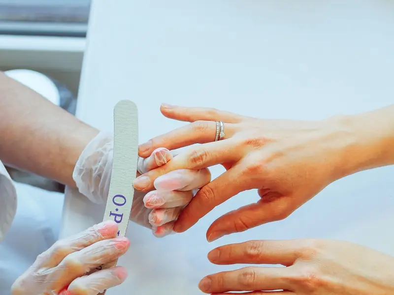 Nail technician working with a regular client