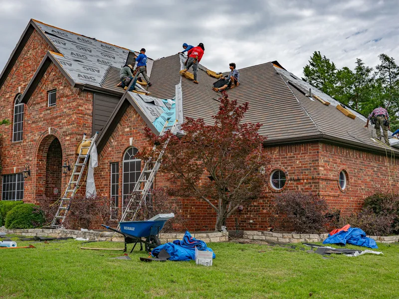 Roofing crew replacing the roof on a brick home